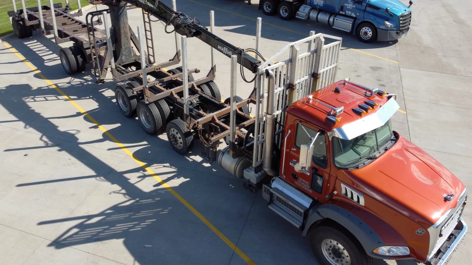 An aerial view of a truck being loaded with lumber in a yard