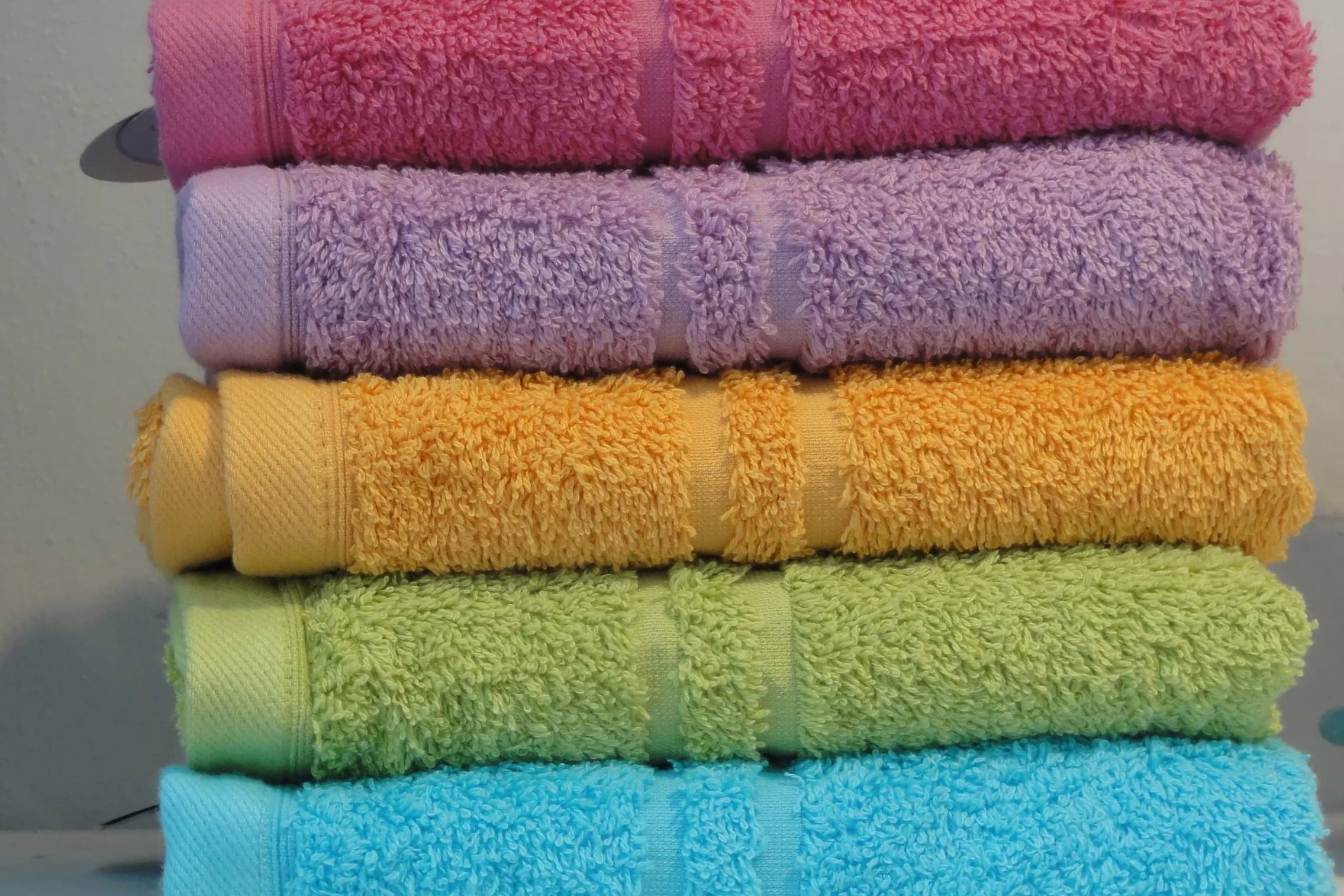 A stack of folded towels in several colours