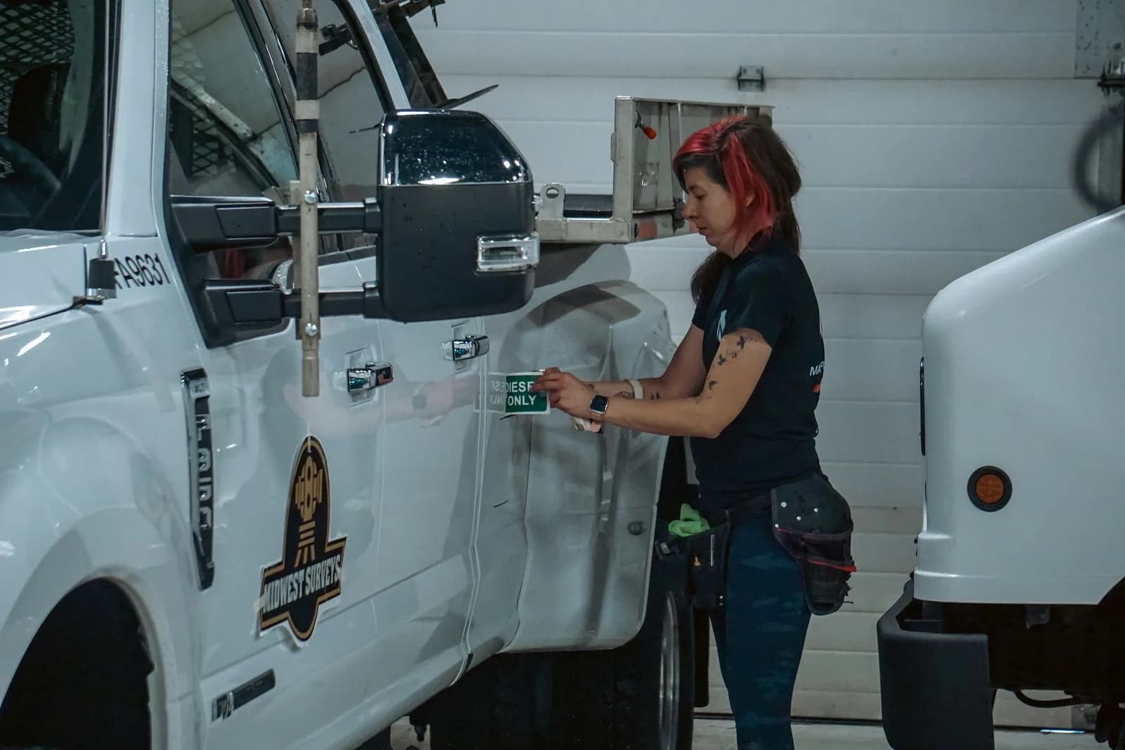 A worker loading equipment through the side door of a white van